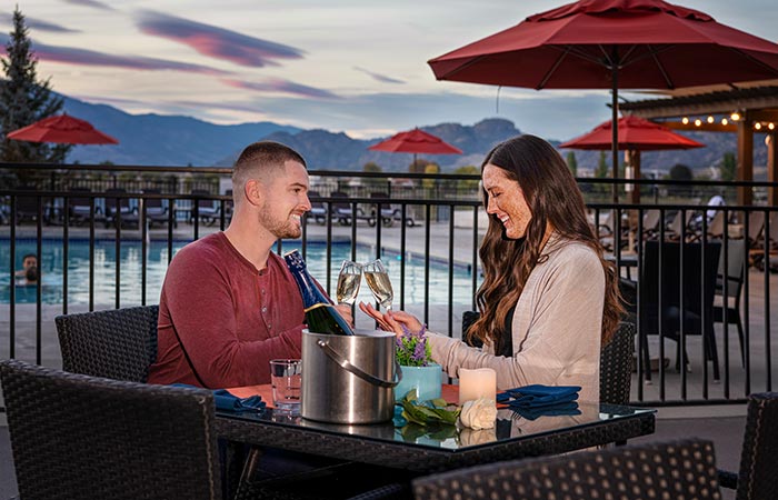 Couple with wine on the patio at Walnut Beach Resort